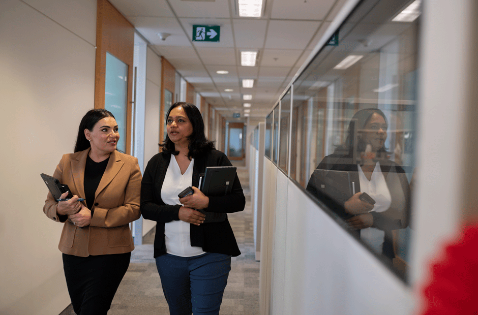 Eva Mohammed (Strategic Research) and Gayathri Ravi Shankar (Strategic Research) discuss research projects in a corridor