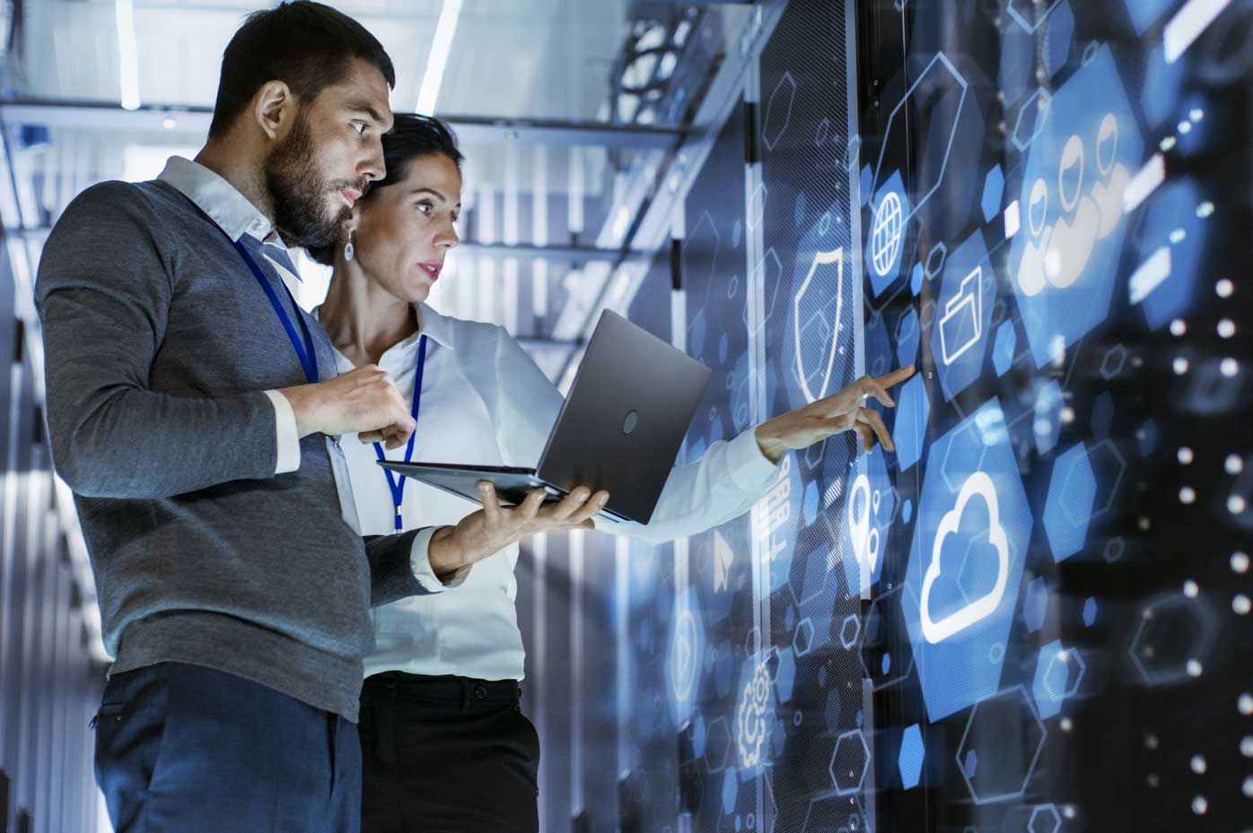 A pair of analysts examine cyberprotections in a server room