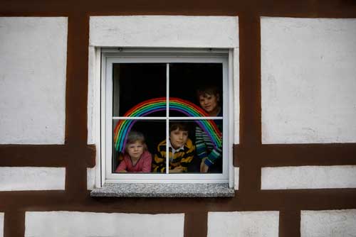 Children gazing out of window on lockdown