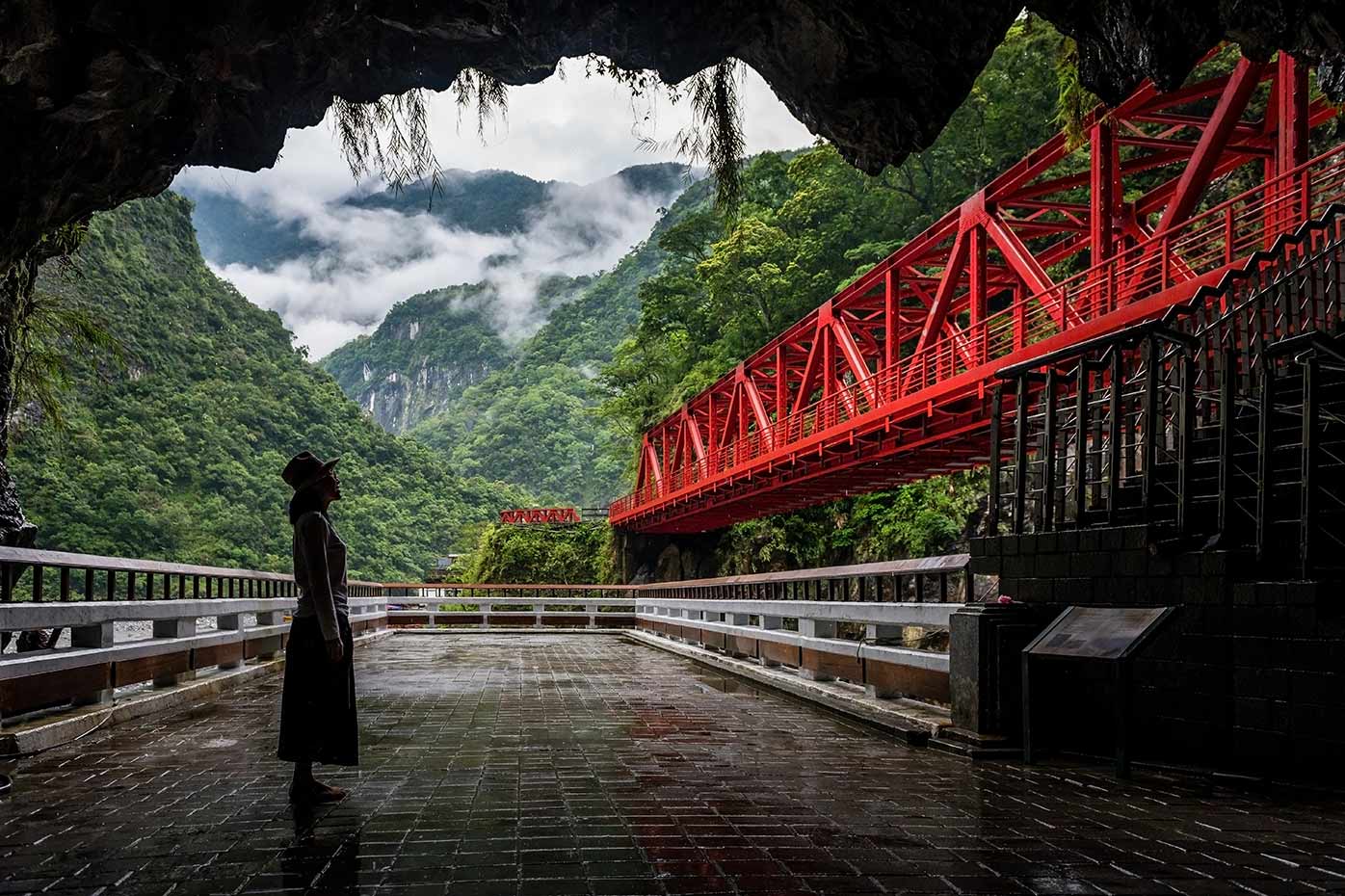 Women looking at red bridge in park in Taiwan