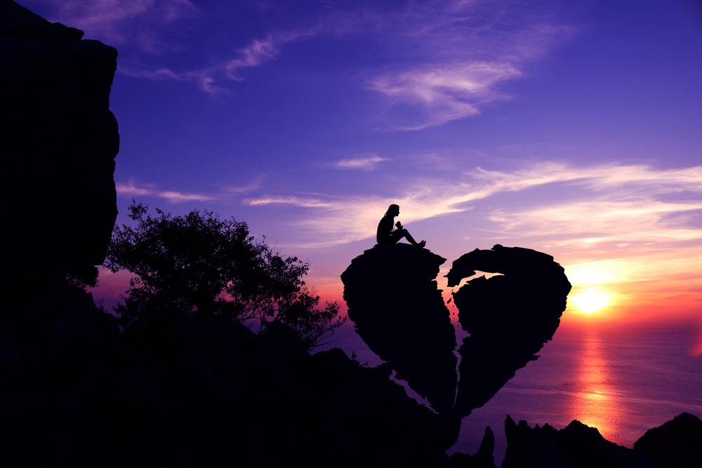 Broken Heart: Illustration of person seated over broken heart shaped rock