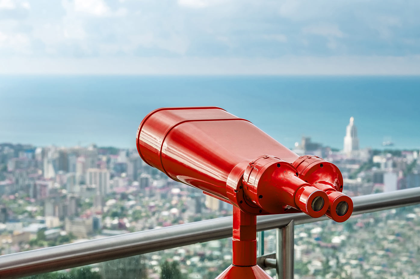 Red telescope overlooking city