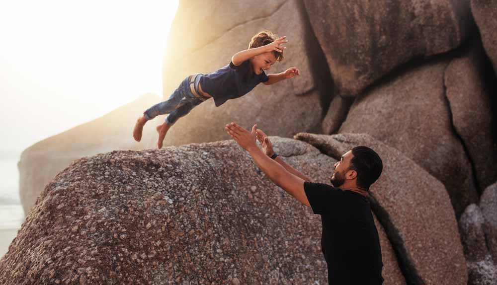 Child leaps to waiting father holding out hands to catch him