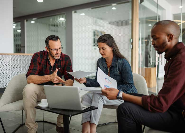 A cluster of people gathers around a laptop