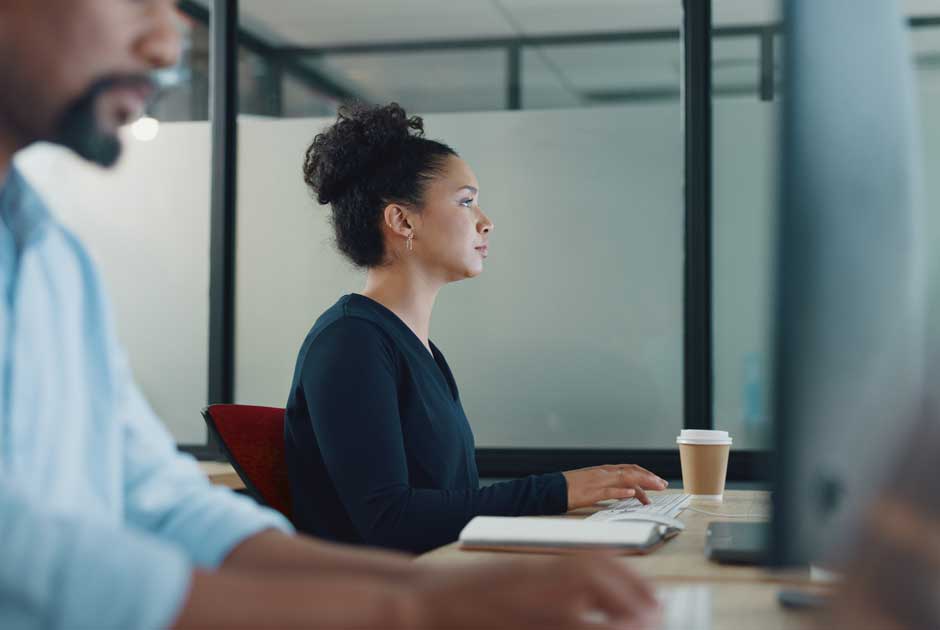 A woman focuses intently on computer as she participates in a Learning Gateway session